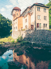 Building by river against sky