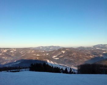 Scenic view of snowcapped mountains against blue sky