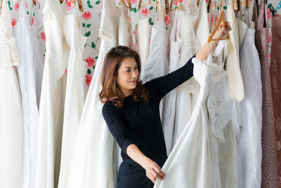 Young woman standing against curtain