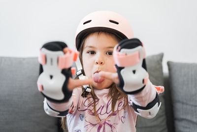 Preschool girl portrait with safety for outdoors activities. pink helmet and wrist pads