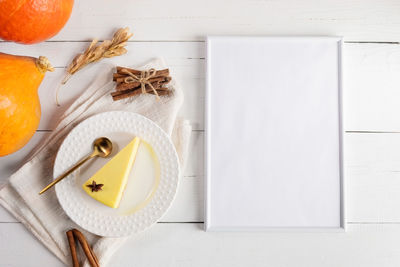 Pumpkin pie piece on white plate, pumpkins, empty frame. thanksgiving, halloween. top view. mock up