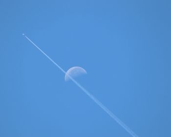 Low angle view of vapor trail against blue sky