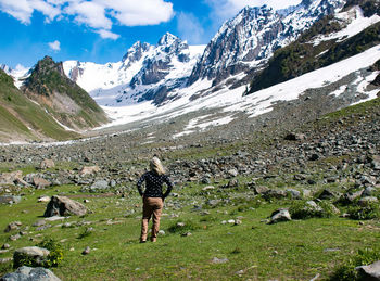 Rear view of woman walking on field
