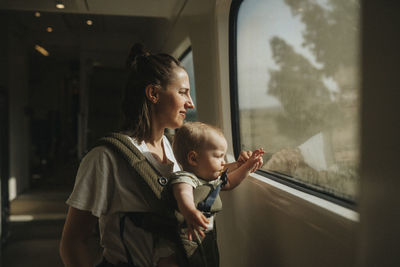 Mother with baby looking through train window