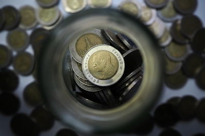 Directly above shot of coins in jar on table