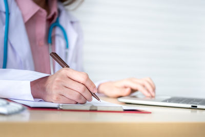 Midsection of woman working on table