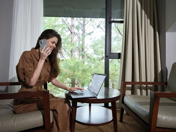 Young woman sitting on chair at home