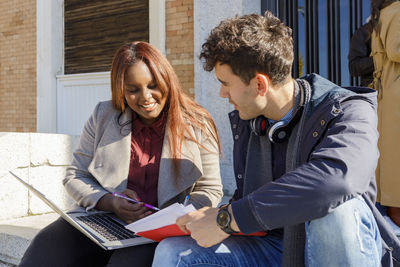 Redhead woman talking with friend on college campus