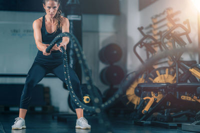 Agility training, woman exercising with rope in a gym.