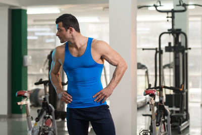 Muscular man wearing vest standing in gym