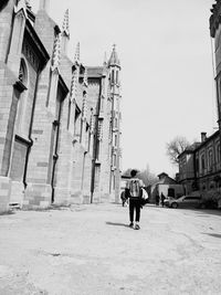 People on street in city against sky