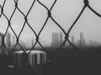 Close-up of chainlink fence against building