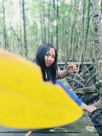 Portrait of smiling young woman in forest