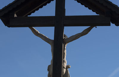 Low angle view of cross against clear blue sky