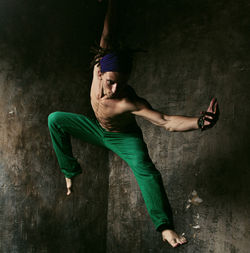 High angle view of young man dancing on wall