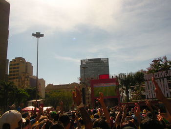 People on street in city against sky