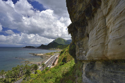 Scenic view of sea by mountains against sky