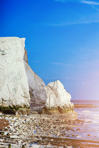 Rock formation on beach against sky