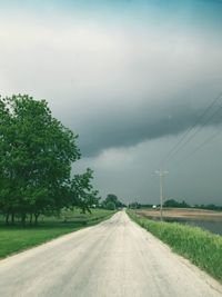 Road amidst field against sky