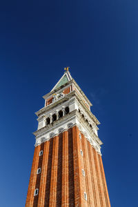 Low angle view of st mark's campanile  against blue sky