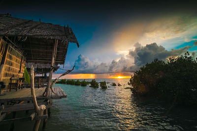 Scenic view of sea and buildings against sky during sunset