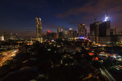 High angle view of illuminated buildings against sky at night