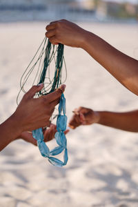 Two women at the beach holding tangled necklace