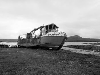 Abandoned boat on sea against sky