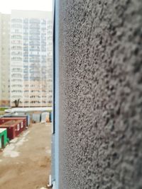 Close-up of wall with buildings in background