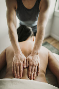 Detail of massage therapists hands on patient's back