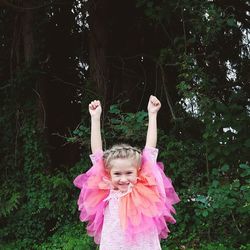Portrait of girl smiling against trees