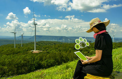 Woman wearing hat while standing on land against sky