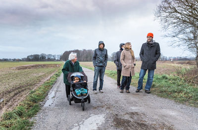 Full length of people standing on road against sky