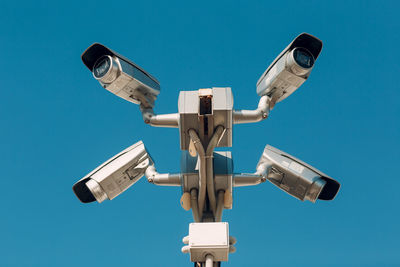 Low angle view of security camera against sky