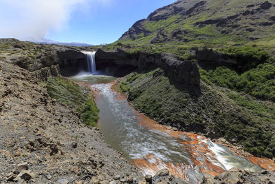 Scenic view of waterfall against sky