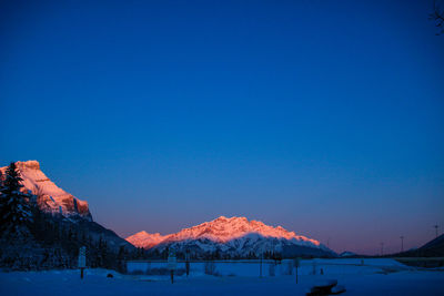 Scenic view of snowcapped mountains against clear blue sky