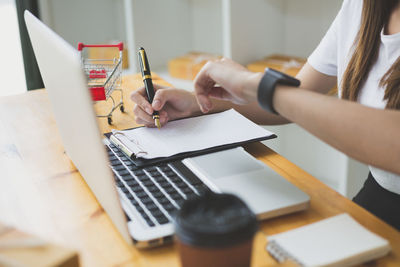 Midsection of woman using mobile phone