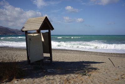 Lifeguard hut on beach against sky