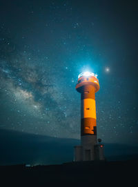 Low angle view of lighthouse against sky at night