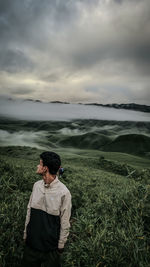 Rear view of woman sitting on field