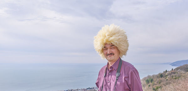 Portrait of happy woman against sea against sky