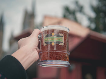 Close-up of hand holding glass of beer