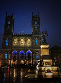Low angle view of illuminated clock tower at night