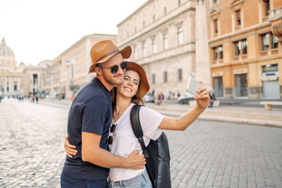 Young woman wearing hat standing in city