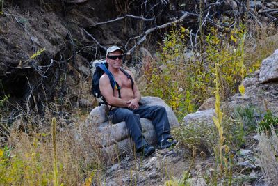 Man sitting on rock in forest