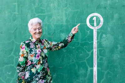 Portrait of smiling woman standing against blue wall