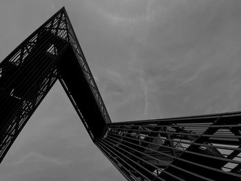 Low angle view of bridge against cloudy sky