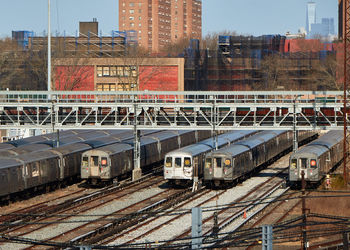 Coney island train yard with several parked nyc trains and skyscrapers visible in the background