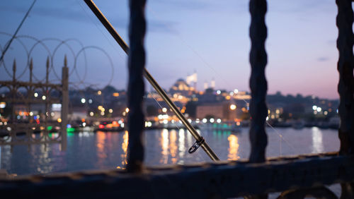 River seen through railing against sky at dusk