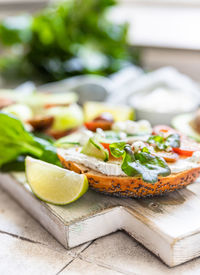 Bagels sandwich with cream cheese, cottage cheese, avocado, tomatoes, cucumbers and salad leaves